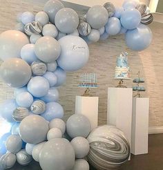 the balloon arch is decorated with blue and white balloons, silver swirls and seashells