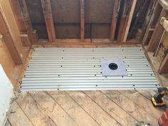 the inside of a room with wooden flooring and metal grate under construction work