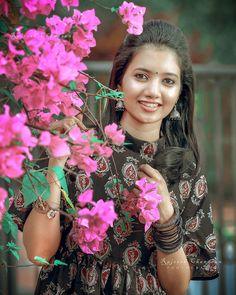 a woman is holding flowers in her hand