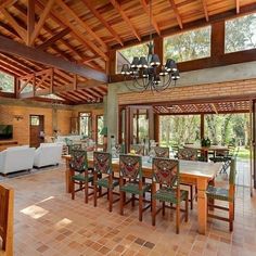 a large dining room with wooden ceiling and tile flooring