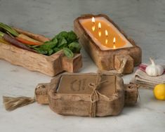 some candles are sitting on a table next to vegetables