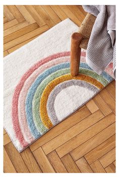 a rainbow rug is on the floor next to a chair