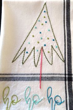 a white towel with a christmas tree embroidered on it