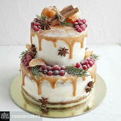 a three tiered cake covered in icing and topped with berries, cinnamons, star anisettes and spices