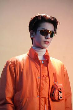 a man wearing an orange jacket and sunglasses