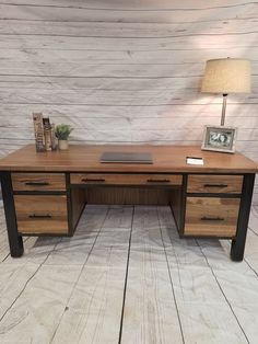 a wooden desk with two drawers and a lamp