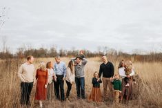 a group of people standing in the middle of a field with one person taking a photo