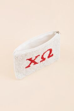 a white zippered pouch with red xo embroidered on it