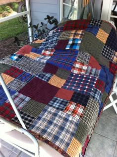 a multicolored patchwork quilt hanging from a metal rail