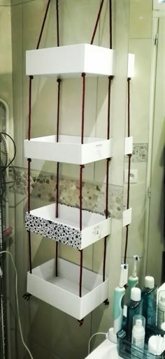 the bathroom is decorated in white and has three shelves on each side that hold boxes