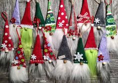 a group of gnome hats hanging from hooks on a wooden wall with snowflakes