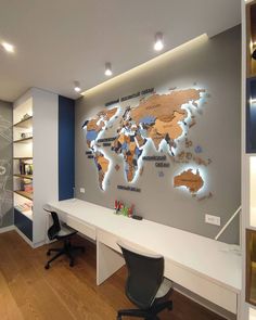 a room with a desk and a world map on the wall above it is lit up by lights