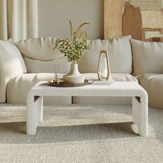 a living room with a white couch and coffee table