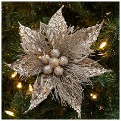 a christmas ornament hanging from the side of a tree with lights on it