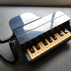 an old fashioned black and yellow phone on the floor