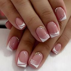 a woman's hands with pink and white nail polishes on their nails,