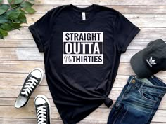 a t - shirt that says straight out in white on top of a wooden table