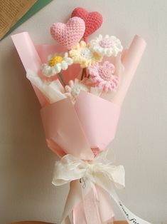 a bouquet of flowers is wrapped in pink paper