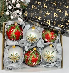 six christmas ornaments are in a box on the table