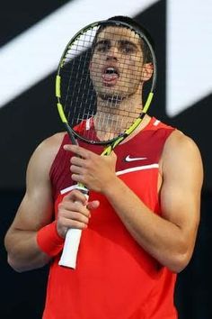 a man holding a tennis racquet on top of a tennis ball racket