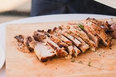 sliced meat sitting on top of a wooden cutting board