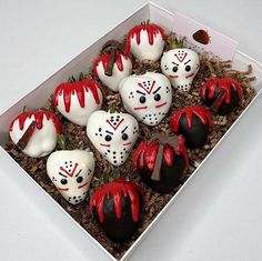 a box filled with white chocolate covered in red and black frosted marshmallows