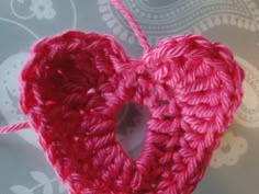 a red crocheted heart hanging from a string