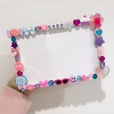 a close up of a person's hand holding a frame made out of candy