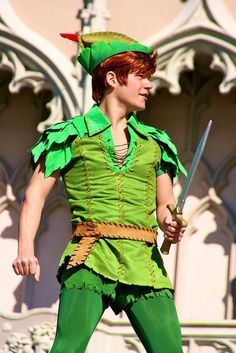 a man dressed in green and holding two swords