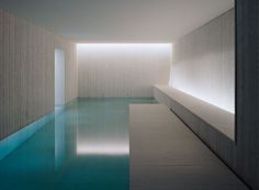 an empty swimming pool in the middle of a room with light coming from it's windows