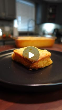 a black plate topped with fried food on top of a wooden table