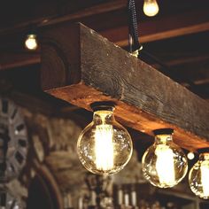 three light bulbs hanging from the ceiling in a room with wood beams and chandeliers