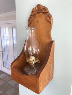 a wooden shelf with a glass vase on it