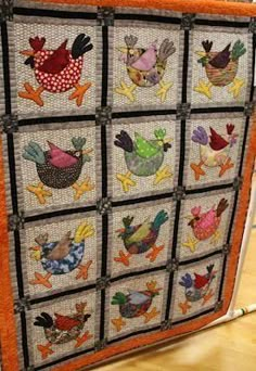 a quilted wall hanging with chickens on it