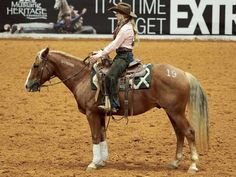 a woman riding on the back of a brown horse