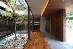 the inside of a house with wood flooring and glass walls on either side of it