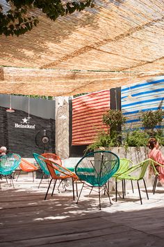 colorful chairs and tables under an awning