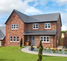 a large brick house sitting on top of a lush green field