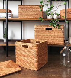 wicker baskets and vases are on the floor in front of a bookshelf