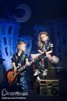 two young children are playing with guitars