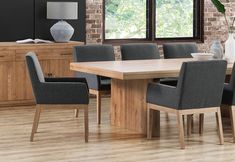 a dining room table with grey chairs next to a brick wall