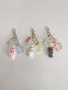 six different key chains with small charms attached to them on a white surface in the shape of animals