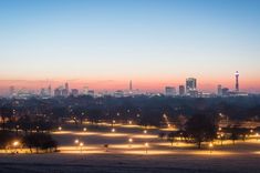 the city skyline is lit up at night, with lights shining in the foreground