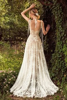 the back of a woman's wedding dress, with her hands on her head