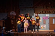 a group of people standing on top of a stage with signs in front of them