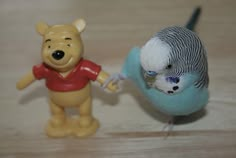 two toy figurines, one with a bird on its back