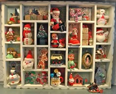 a shelf filled with lots of different types of christmas decorations and figurines on top of it