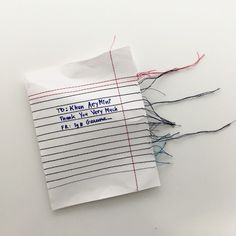 a piece of paper that has some thread on it and is taped to the side