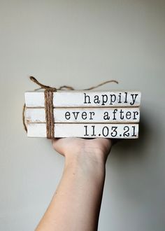 a hand holding two books with the words happily ever after 11 01 21 on them