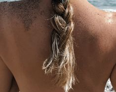 the back of a woman's head with sand all over her body and hair